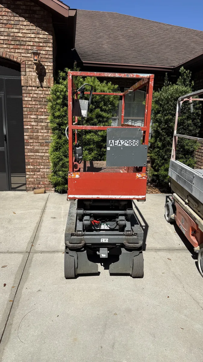 19-foot electric scissor lift delivered to a residential driveway in Sanford, FL by Service Rents LLC
